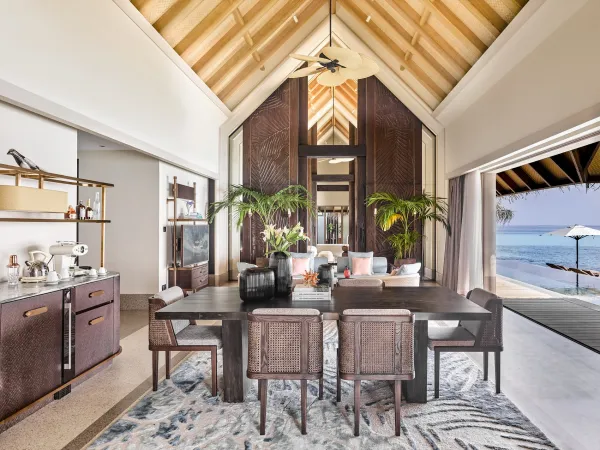 Open-plan living and dining area with vaulted ceiling and ocean-view terrace inside JOALI Maldives Three-Bedroom Residence.