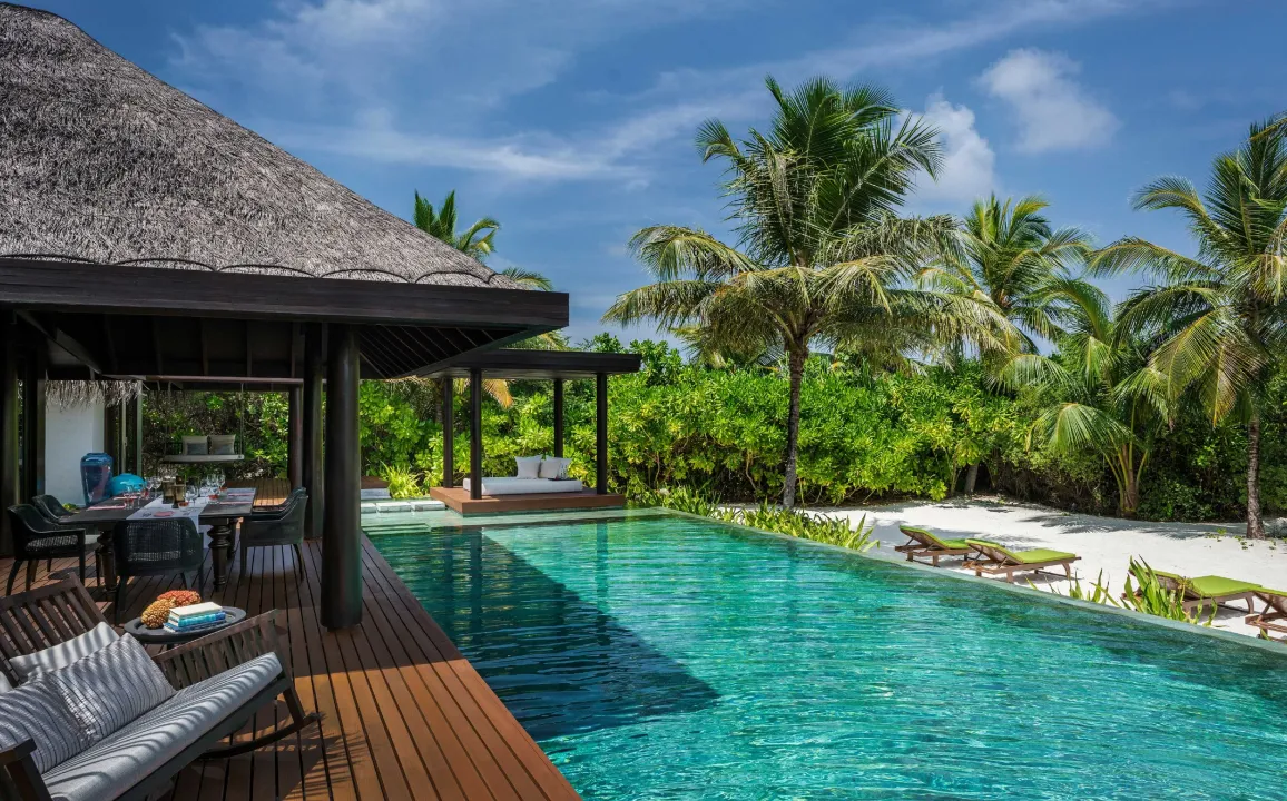Luxury beachfront residence at Velaa Private Island Maldives – private pool, outdoor dining, and tropical garden views.