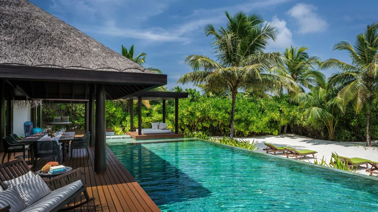 Luxury beachfront residence at Velaa Private Island Maldives – private pool, outdoor dining, and tropical garden views.