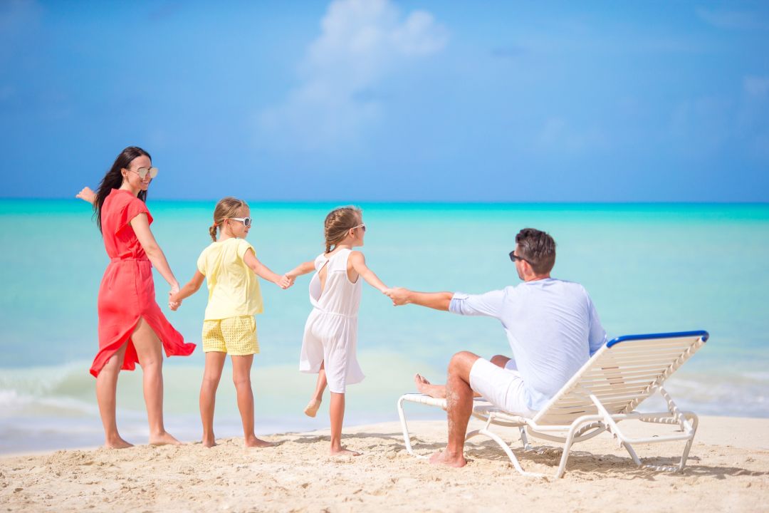 Family walking together on a beach in the Maldives.