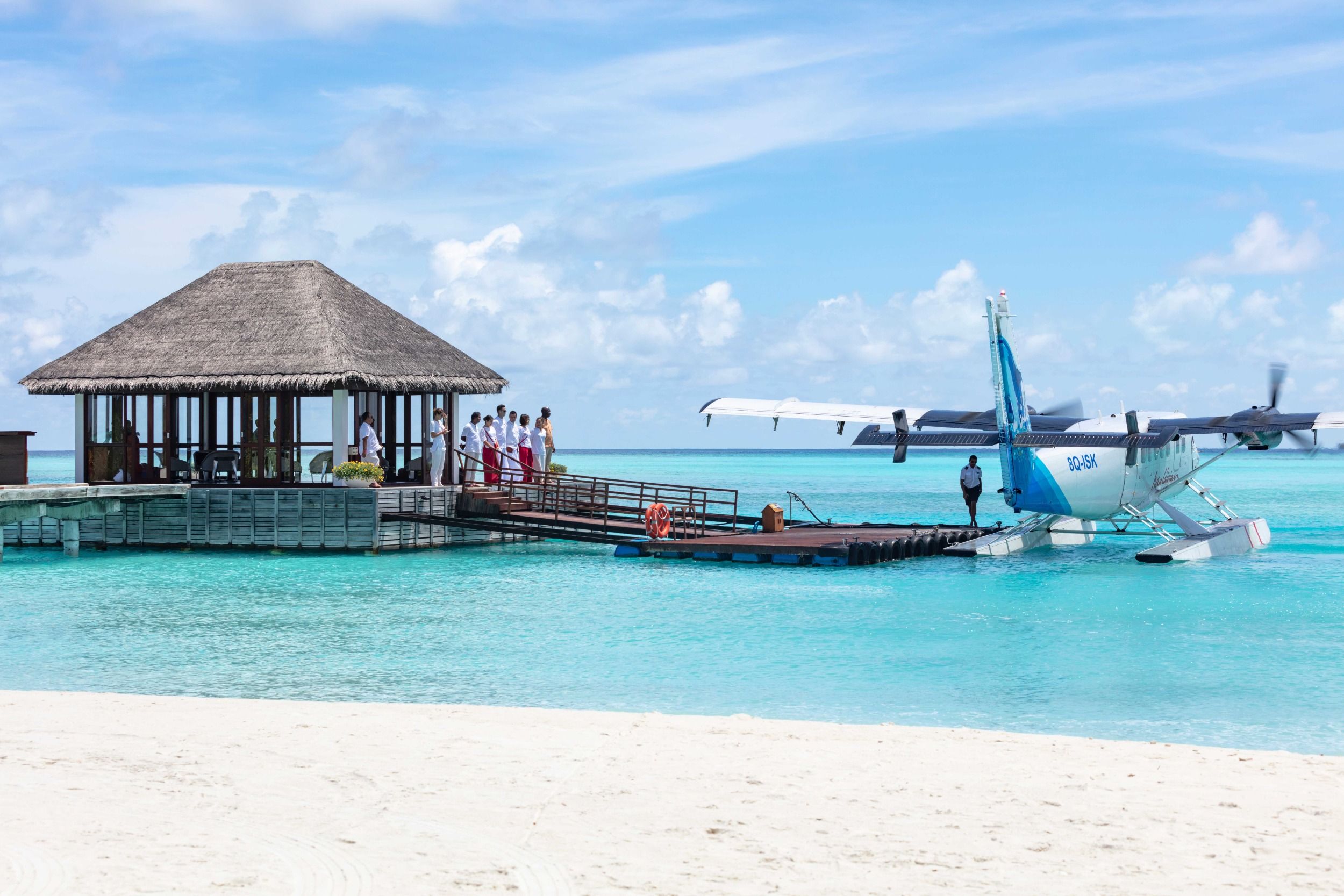 Staff welcoming guests from seaplane at arrival jetty