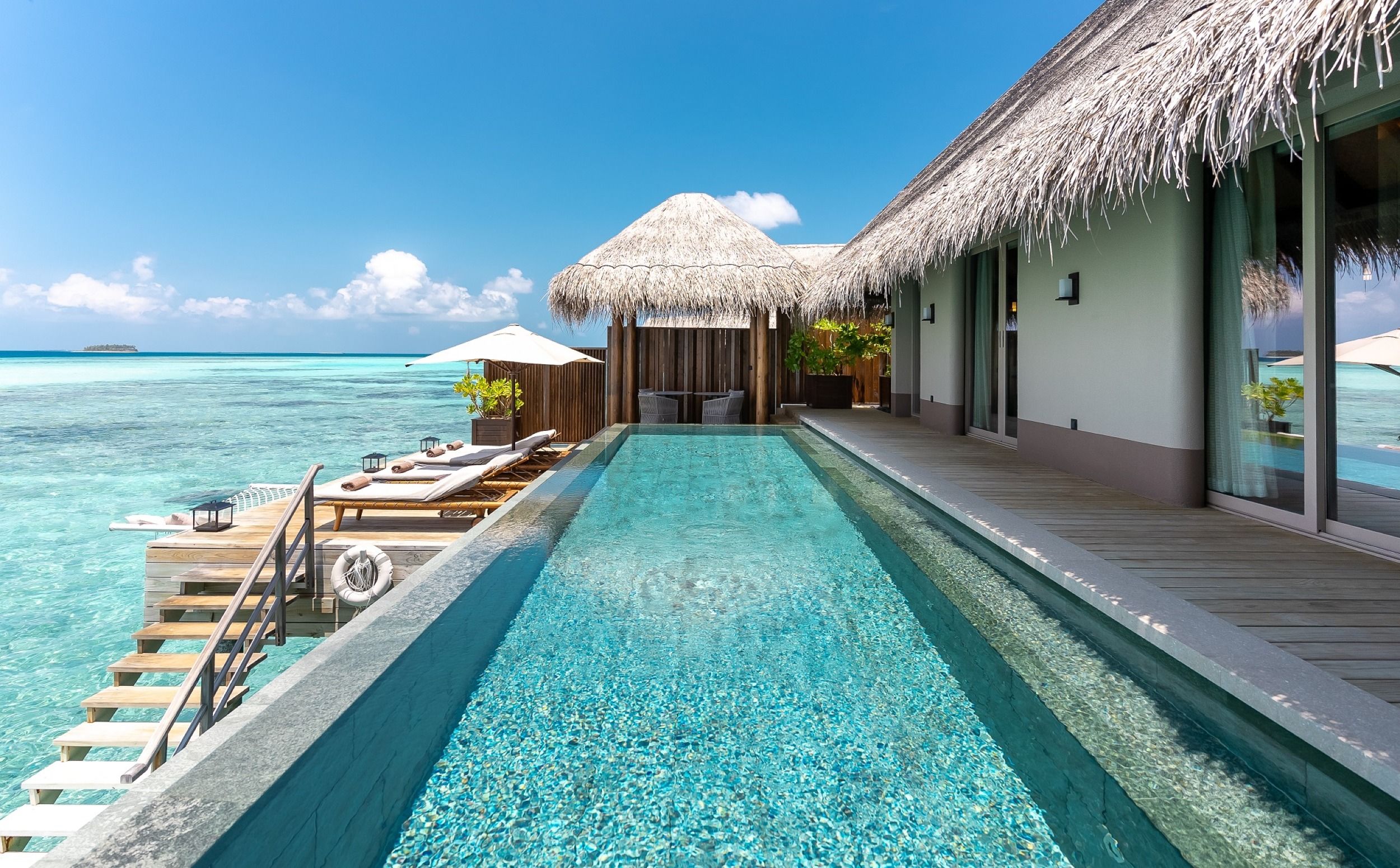 Side view of pool, deck and stairs descending to the ocean