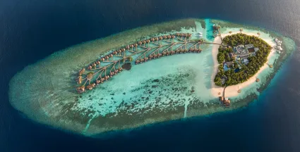 Aerial view of W Maldives luxury resort in North Ari Atoll, featuring overwater villas and turquoise lagoons